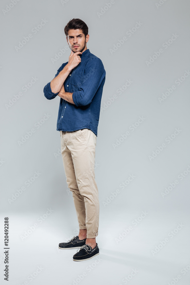 Full length portrait of a thoughtful man looking at camera Full length portrait of a thoughtful man looking at camera