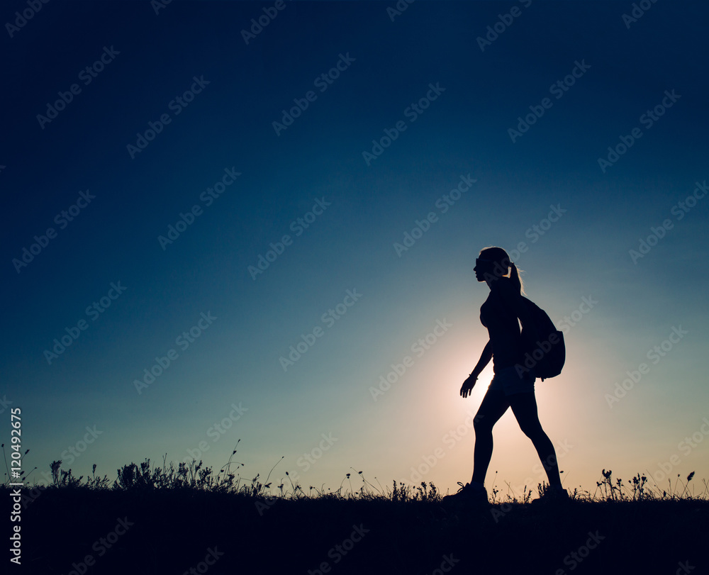 silhouette Young woman tourist with backpack goes on the background on sunset sky silhouette Young woman tourist with backpack goes on the background on sunset sky