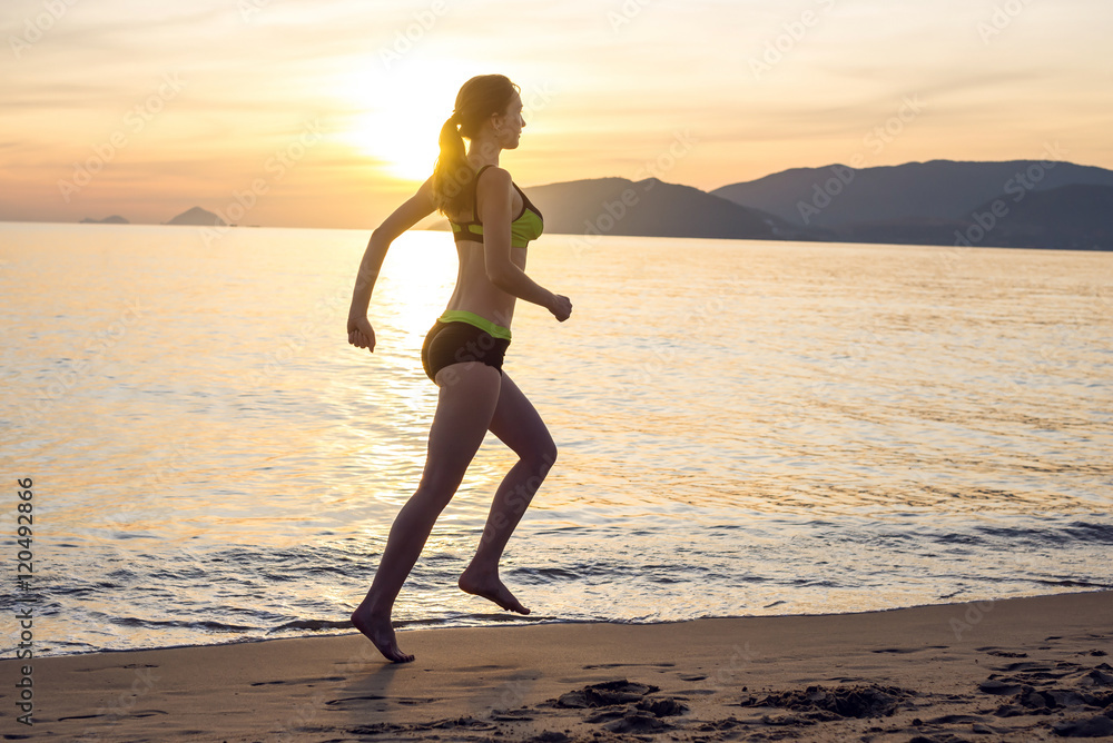 Woman Running on the Beach at Sunset Woman Running on the Beach at Sunset