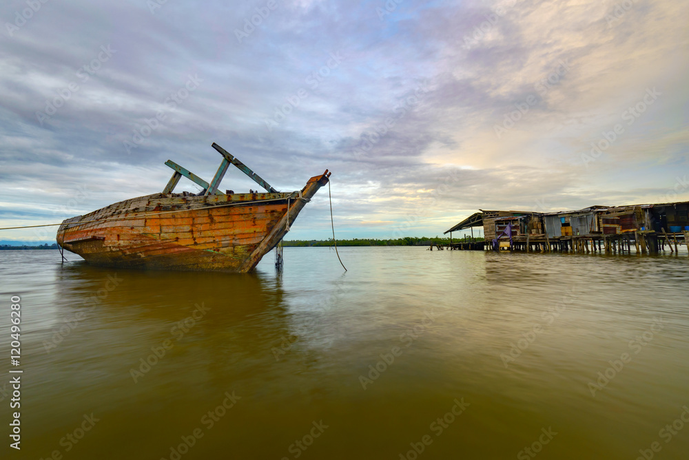 Fishing boat wreckage at water village in Kuala Penyu, Malaysia Fishing boat wreckage at water village in Kuala Penyu, Malaysia