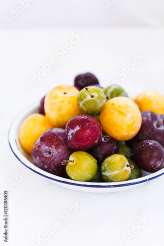  Fresh plums on a white kitchen table.