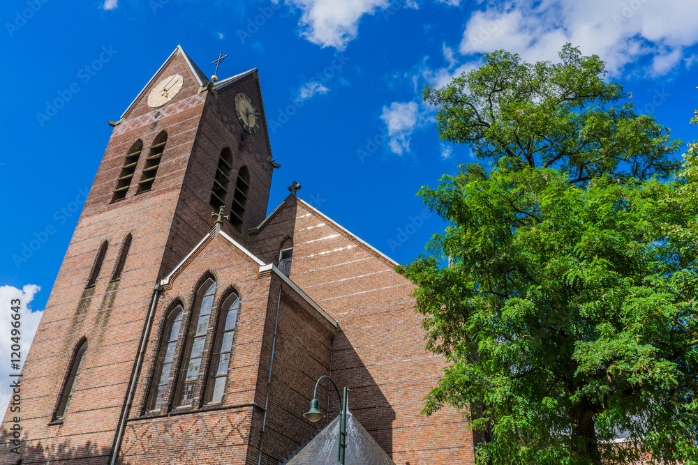 Fototapeta premium front oldstyle church clock tower view with tree