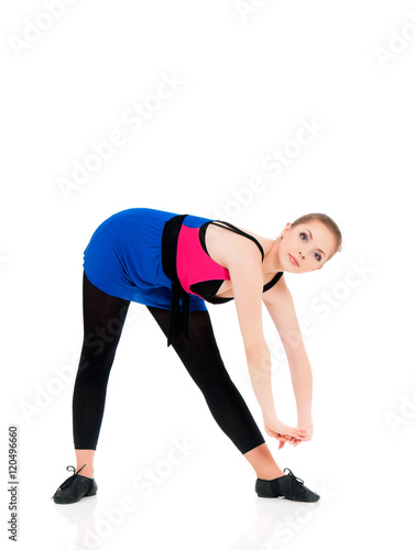 Healthy lifestyle - full length portrait of smiling young fitness girl in perfect shape. Sporty caucasian female model isolated on white background. Cheerful young woman doing stretch exercise. 