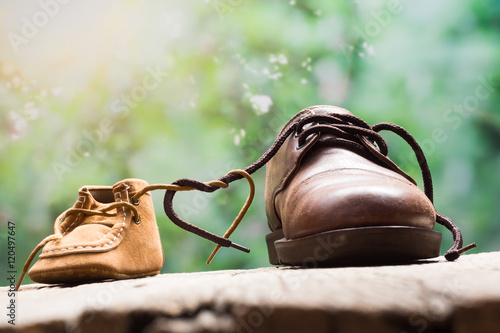 father and child shoes tie the shoestring together in heart shape, love and bound concept