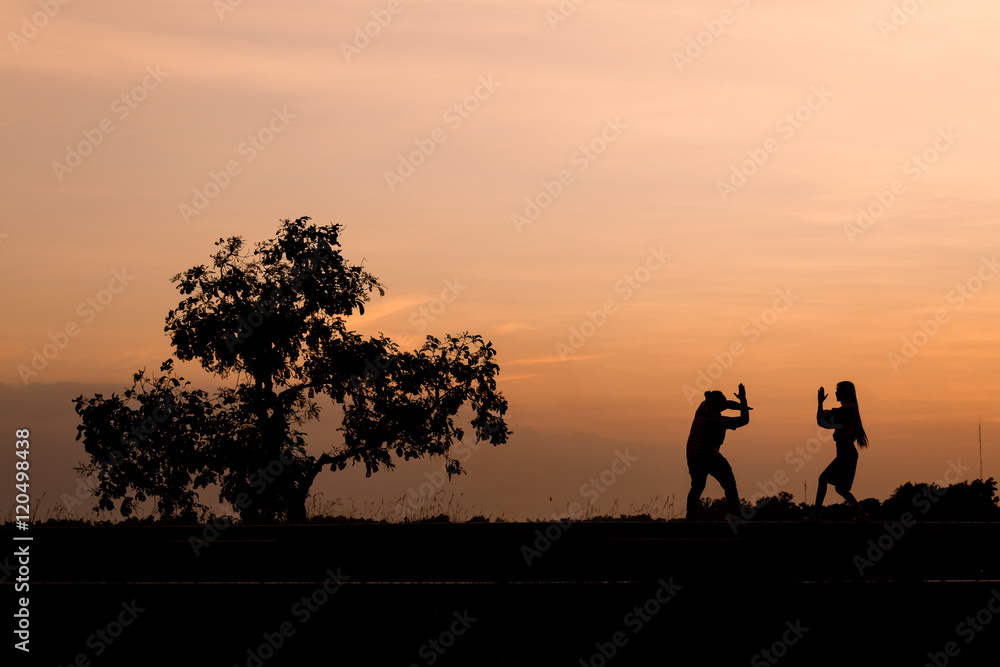 Silhouette man and woman with beautiful the sky at sunset..Backg