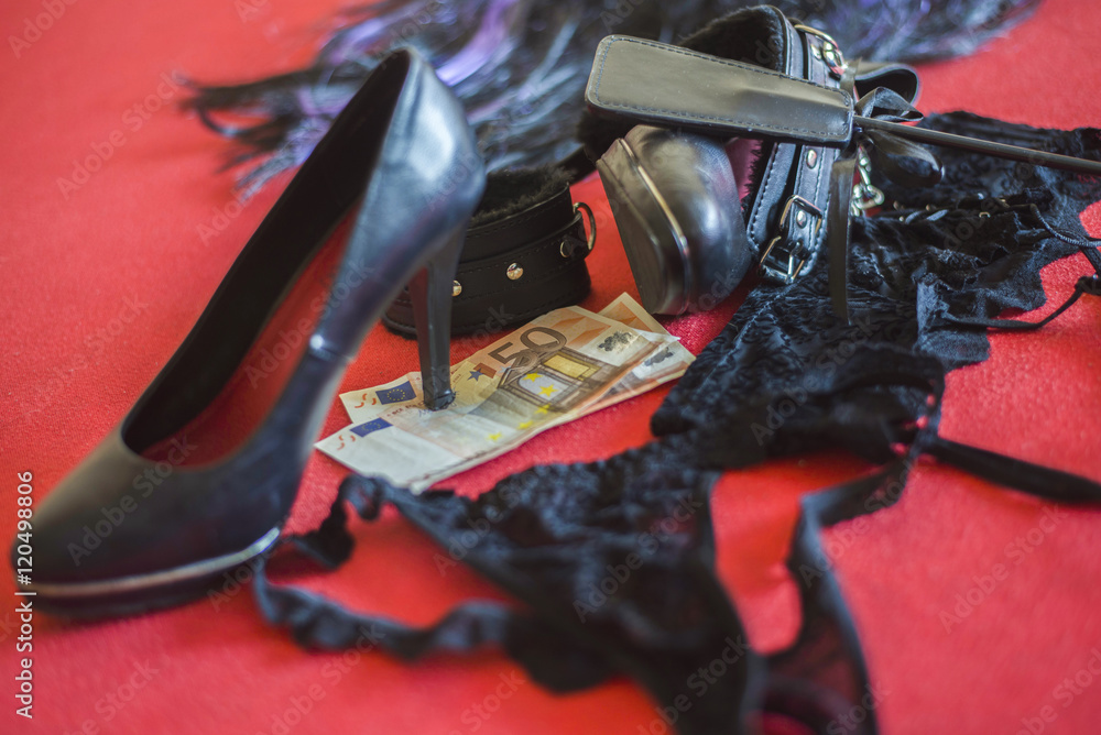 prostitute or striptease concept, 50 euro banknot with sex toys on red bed