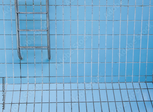 Empty swimming pool with metal ladder