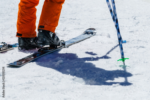 Snowshoes and man legs with orange trousers