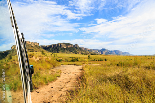 Rocky mountain formation seen from a bus in a green valley on a