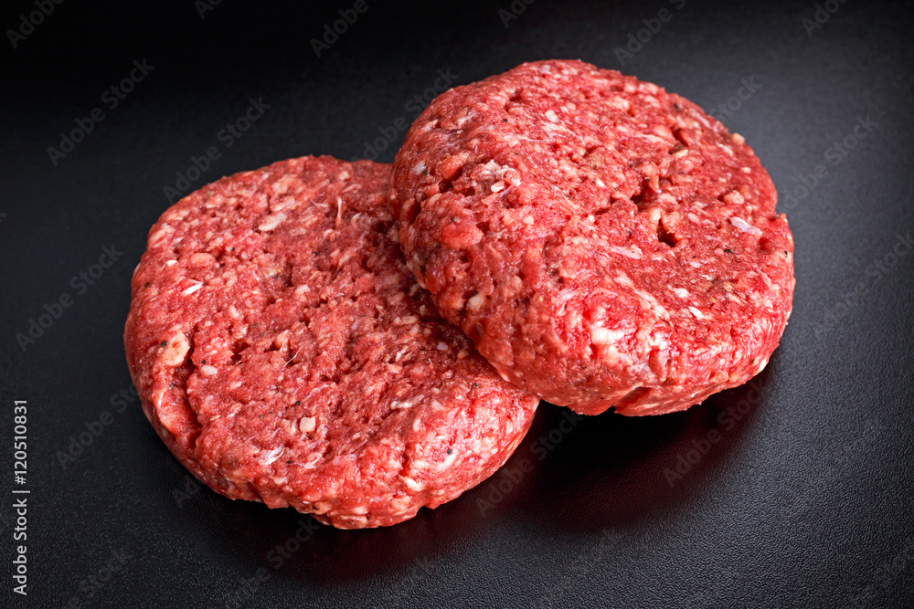 Home HandMade Raw Minced Beef steak burgers on black board Home HandMade Raw Minced Beef steak burgers on black board