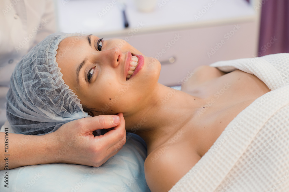 beautiful young woman lying relaxed in a spa salon and receiving facial massage beautiful young woman lying relaxed in a spa salon and receiving facial massage