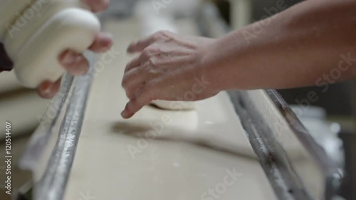 Machine for the Manufacture of Soap. The conveyor at the Soap Factory. Female Hands Take The Bars Of Soap