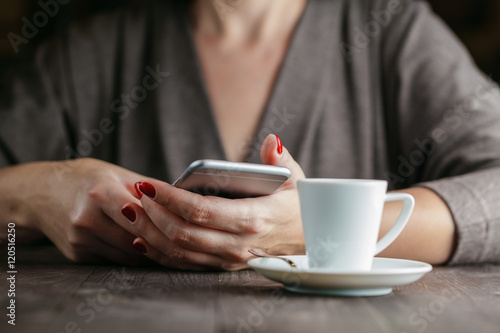 hand woman holding phone and cup of coffee