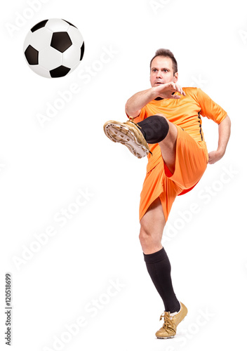Soccer football player kicking the ball isolated on a white background © milkovasa