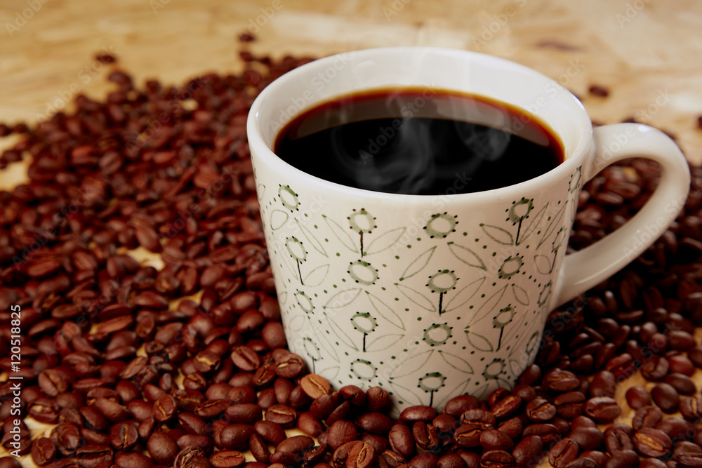 Fototapeta premium Hot coffee with beans on wooden texture