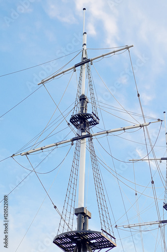 Masts of sailing ship against the blue sky.