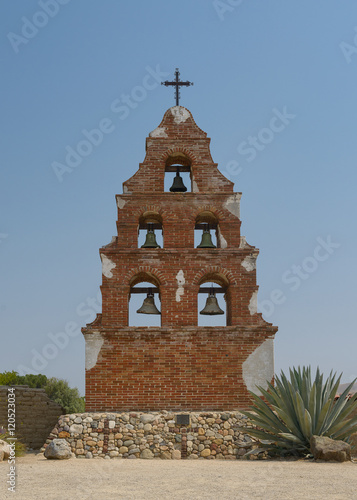 Bell wall (or campanerio) of five bells under cross at Old Mission San Miguel in California