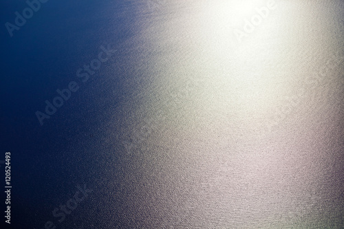 Water sea surface on the sunset, aerial view from the plane porthole