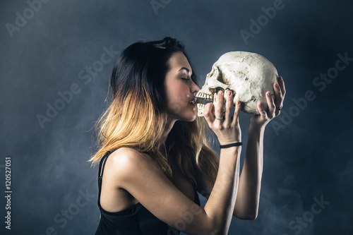 Woman kissing skull