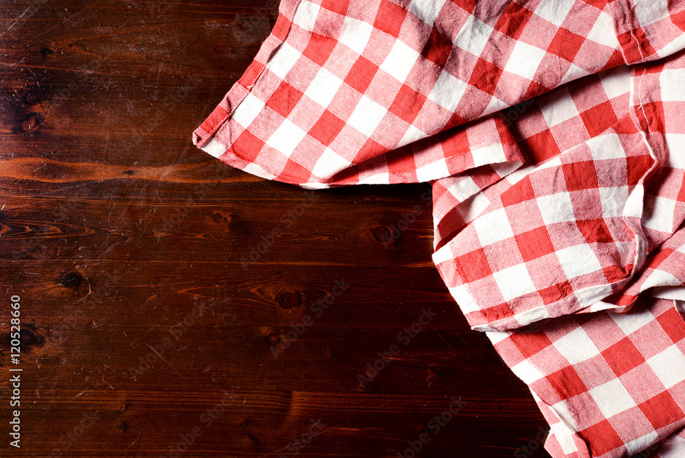 Obraz premium top view of checkered napkin on wooden table