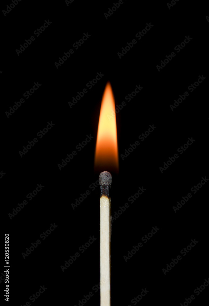 Burning match close-up on a black background. Yellow fire. Burning match close-up on a black background. Yellow fire.