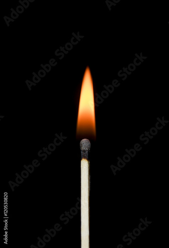 Burning match close-up on a black background. Yellow fire.