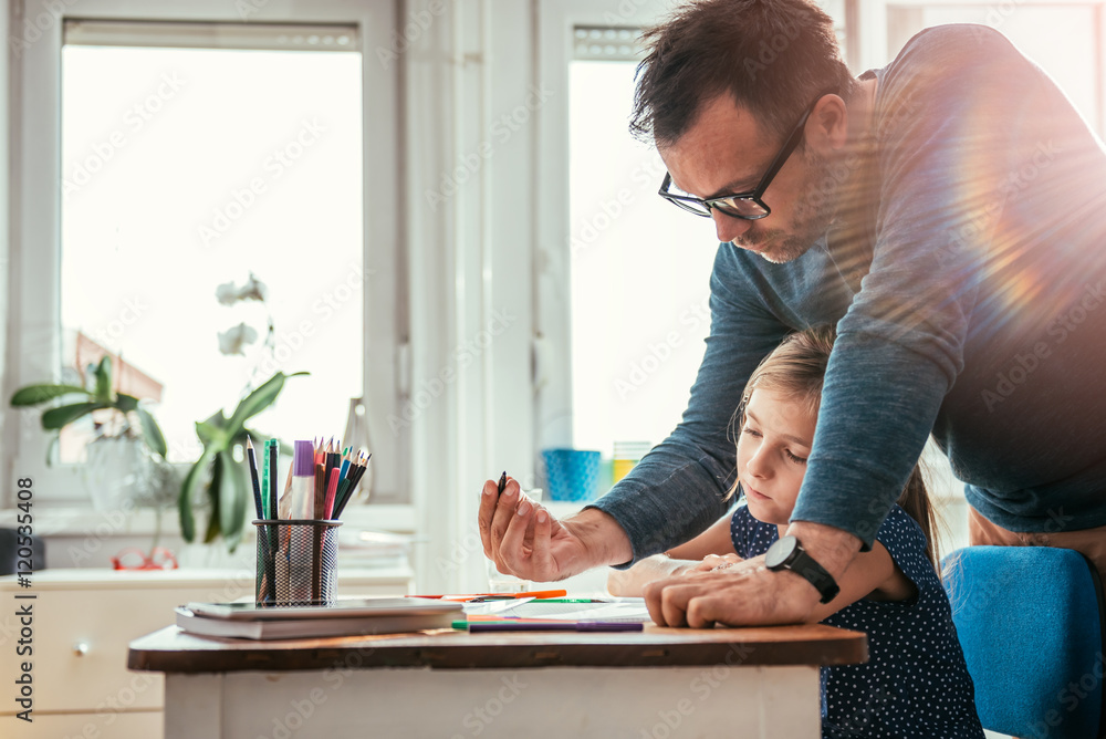 Father helping daughter to finish homework Father helping daughter to finish homework
