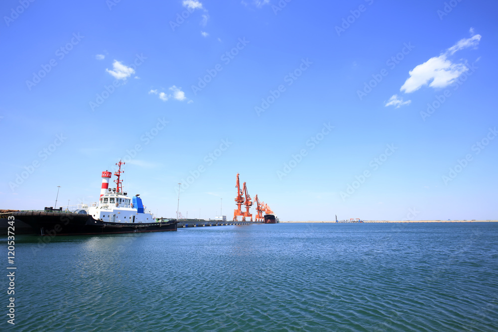 In freight terminal, gantry crane and cargo ships are in loading