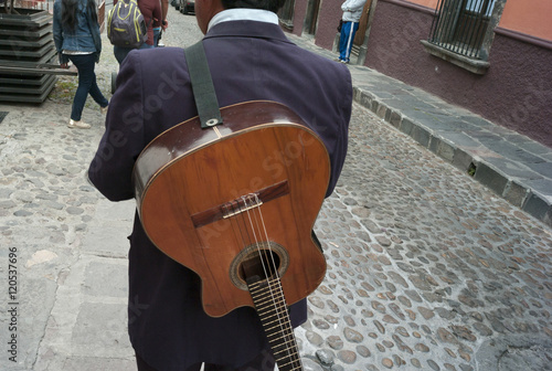 Rear view of a man with guitar on a street, San Miguel de Allend