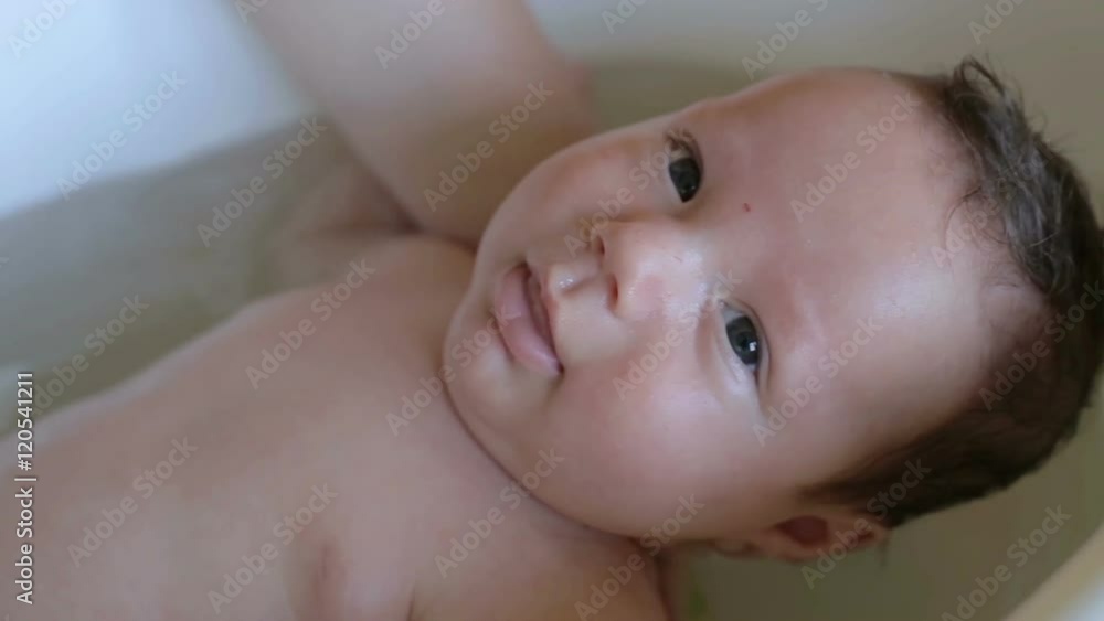 Mother is bathing baby infant
Mother is bathing baby infant