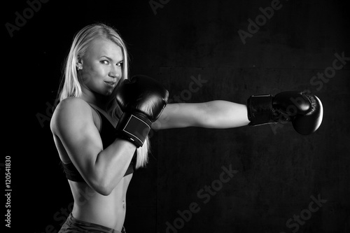 girl with boxing gloves on a black background © zhagunov_a