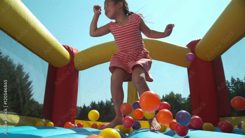 Girl bouncing in inflatable play house, super slow motion