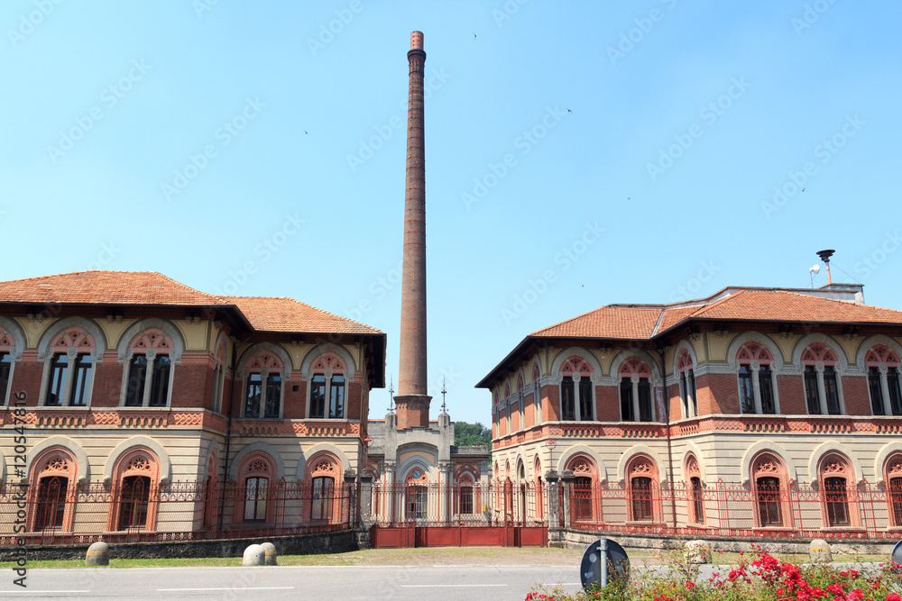 Factory with chimney at historic industrial town Crespi d'Adda near Bergamo, Lombardy, Italy