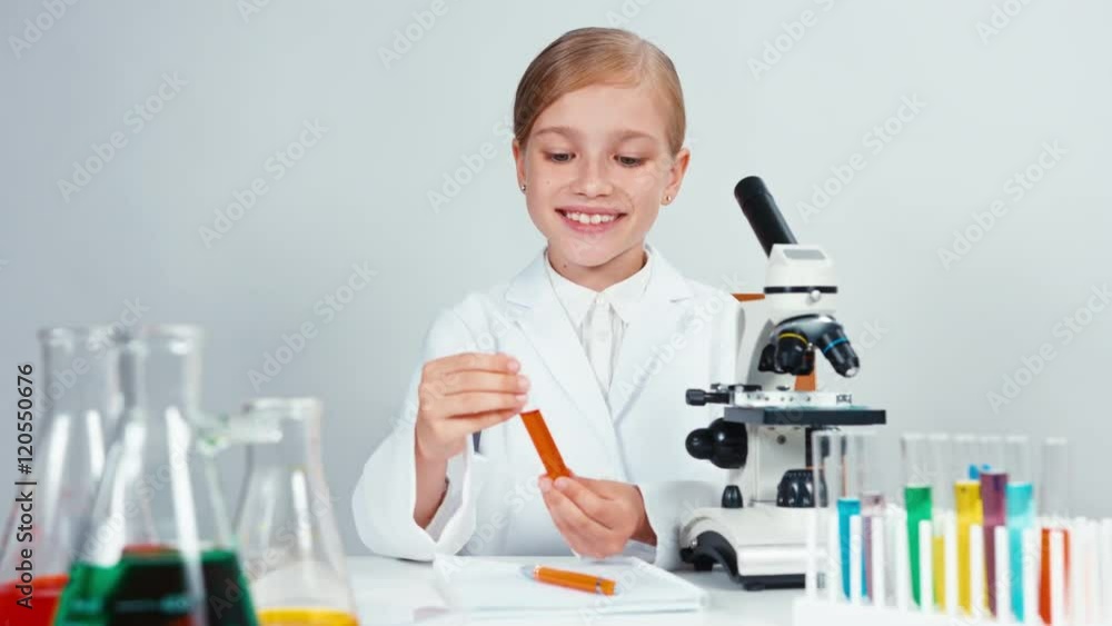 Young chemist holding test tube and smiling at camera Young chemist holding test tube and smiling at camera