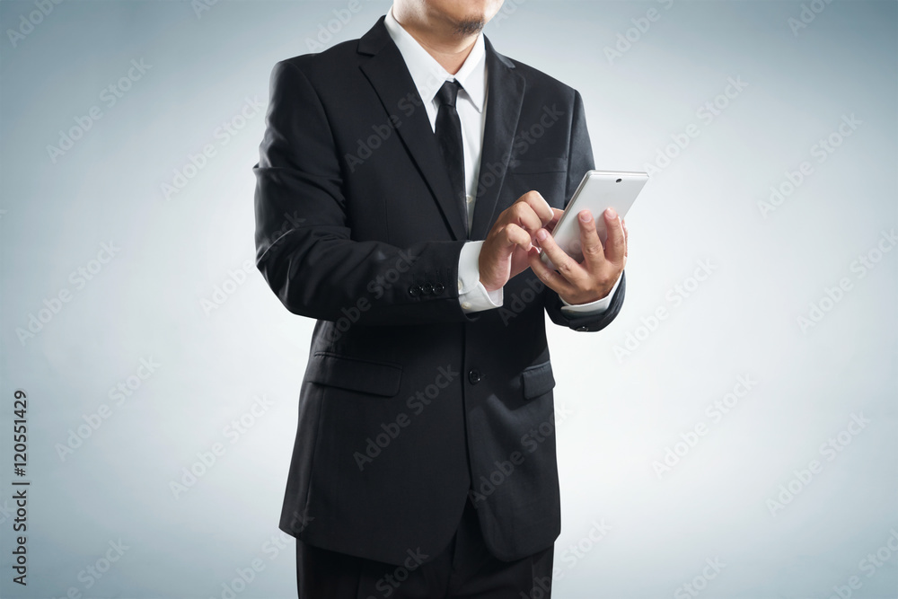 Corporate male executive messaging via phone , with clipping path Corporate male executive messaging via phone , with clipping path