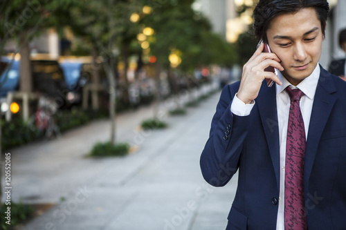 Businessman is talking on the mobile phone in the office district © Monet