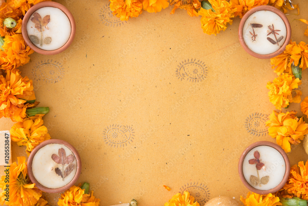 Diwali prayer celebration preparation with sweets and diyas and marigold flowers on handmade paper with Indian motifs  - obrazy, fototapety, plakaty 