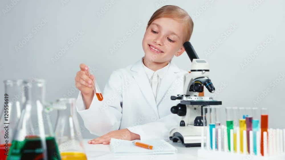 Young chemist school girl holding test tube and looking at camera with smile Young chemist school girl holding test tube and looking at camera with smile