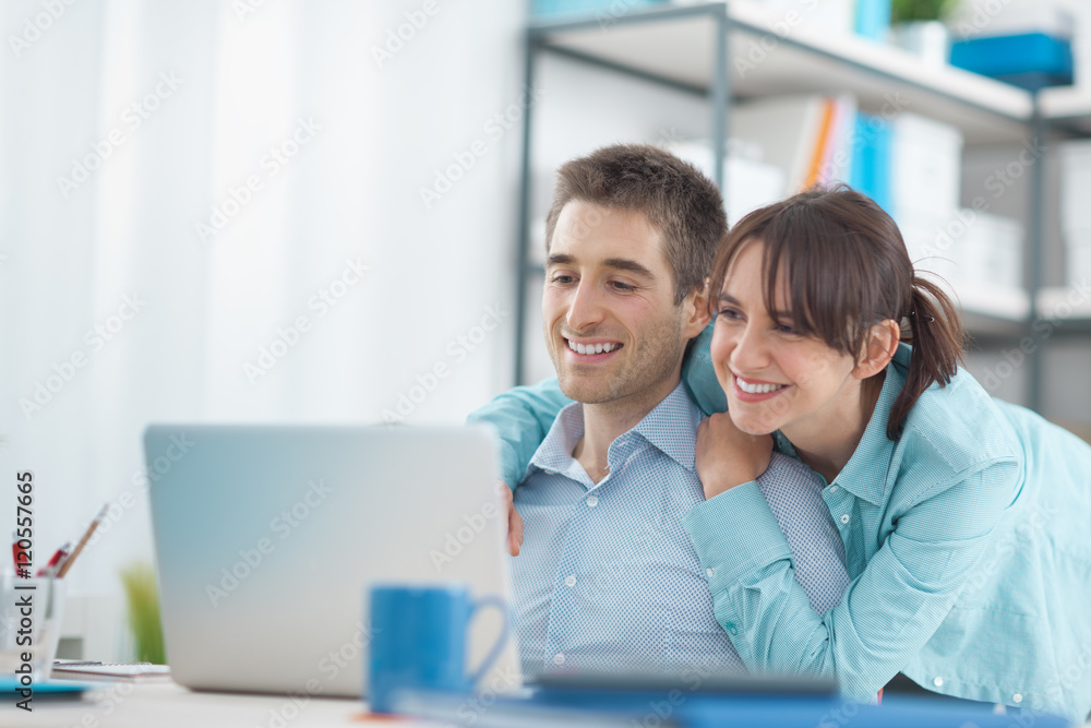 Happy couple at home using a laptop Happy couple at home using a laptop
