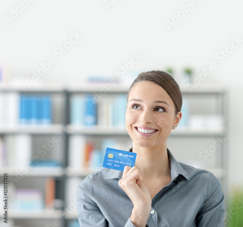 Young smiling woman holding a credit card Free Download Young smiling woman holding a credit card - GFXLoad