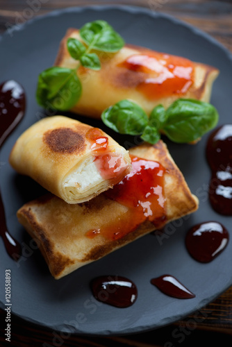 Close-up of crepes with cottage cheese stuffing and jam