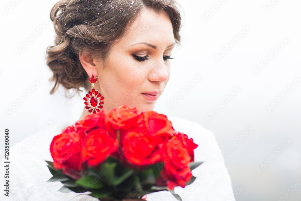 winter bride holding bouquet of red roses winter bride holding bouquet of red roses