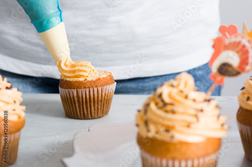 Woman preparing Delicious Thanksgiving Cupcakes photo