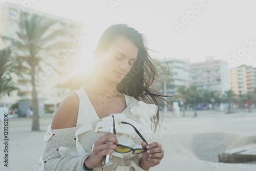 Stylish woman puts on sunglasses photo