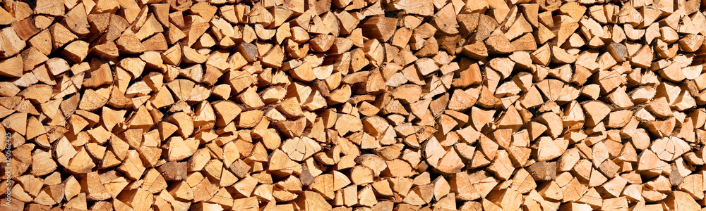 Panoramic photo of a stack of wood logs for winter, wooden header, abstract background Panoramic photo of a stack of wood logs for winter, wooden header, abstract background