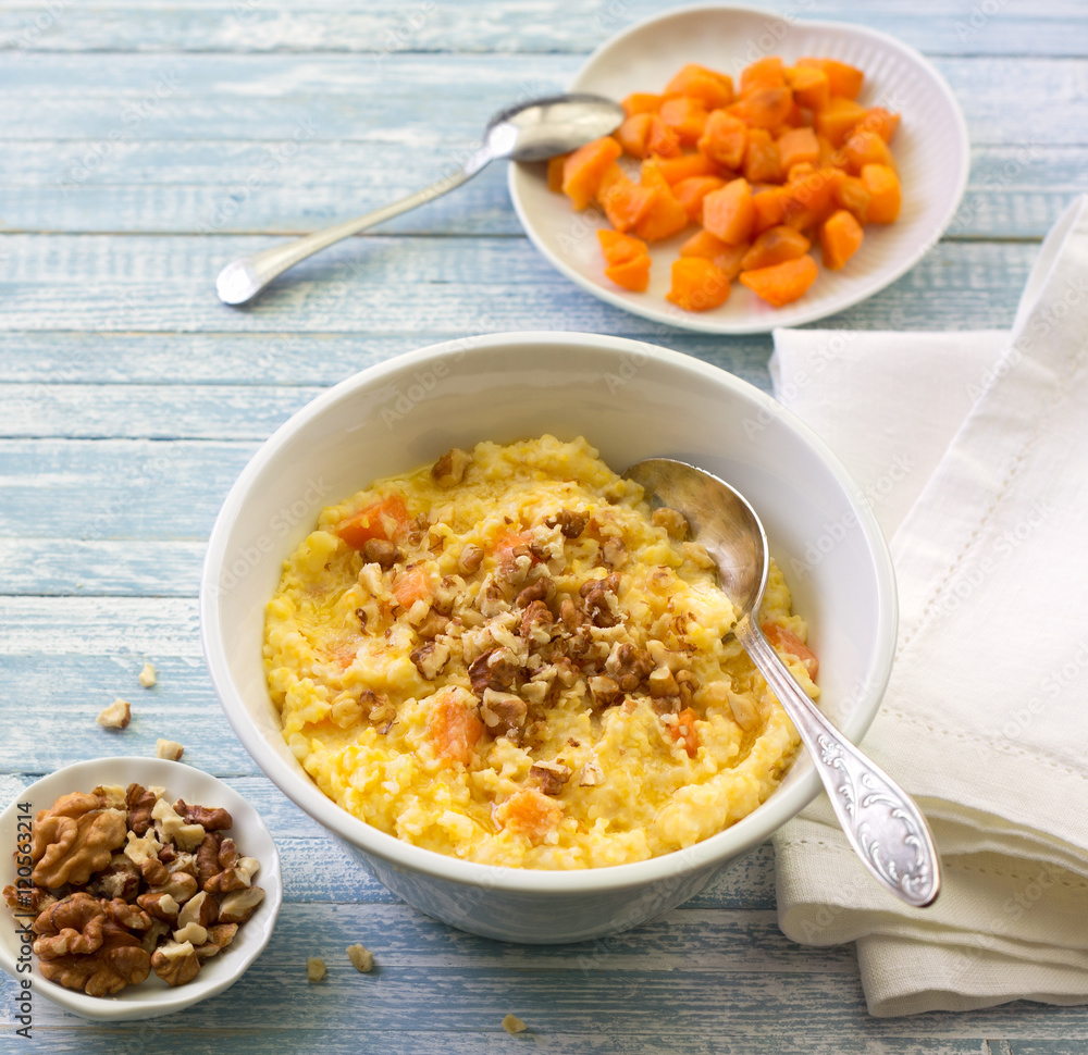 Corn porridge with pumpkin, honey and walnuts on a blue wooden background Corn porridge with pumpkin, honey and walnuts on a blue wooden background