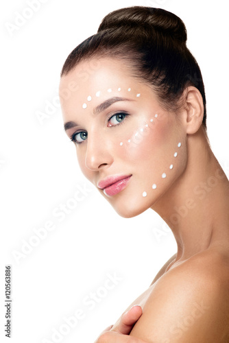 Beautiful Young Woman applying facial moisturizing cream.Skincar