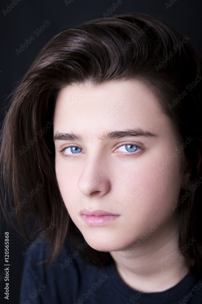 A portrait of a handsome blue eyes teenager on dark background A portrait of a handsome blue eyes teenager on dark background