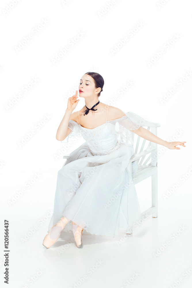 Ballerina in white dress sitting, studio background. Ballerina in white dress sitting, studio background.