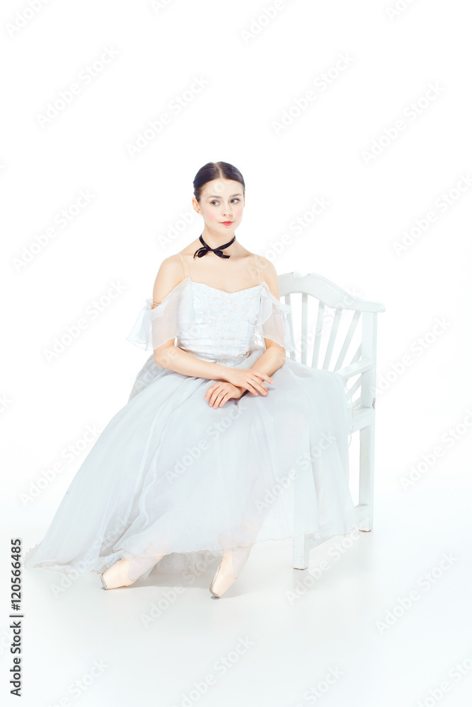 Ballerina in white dress sitting, studio background. Ballerina in white dress sitting, studio background.
